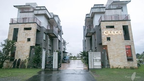 A modern building with a stone facade, multiple balconies, and a gated entrance. - Happy Snails (Wujie)