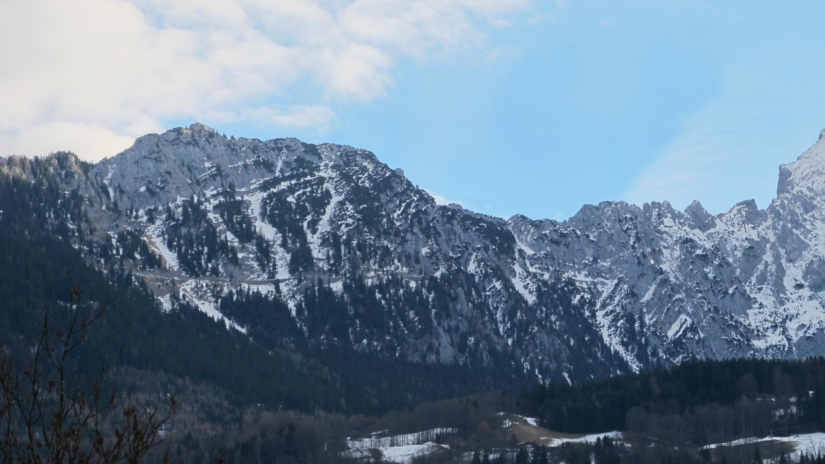A mountainous landscape with snow-covered peaks and a clear sky.