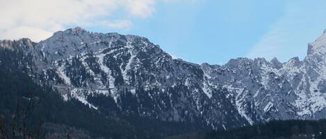 A mountainous landscape with snow-covered peaks and a clear sky.