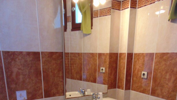 Un baño con inodoro, lavamanos y espejo.