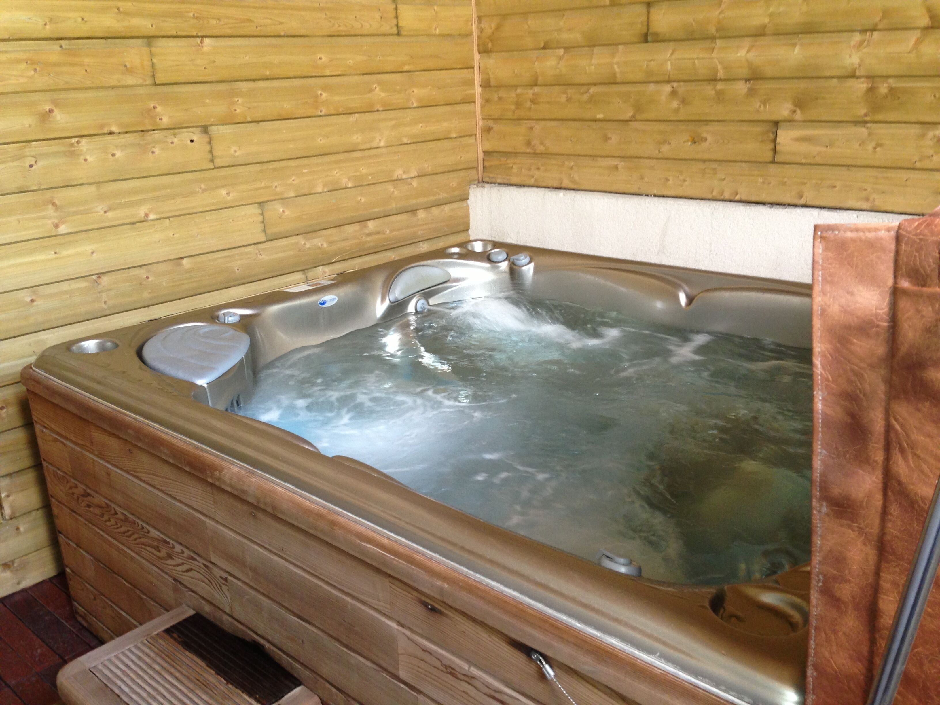 Een houten hut met een jacuzzi.