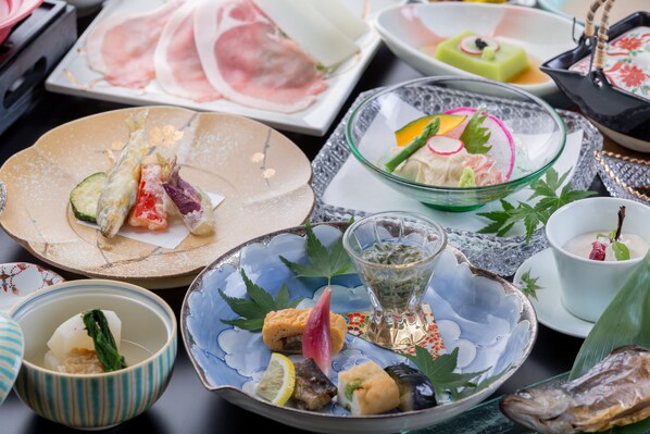 Variedad de platos en una mesa, incluyendo sushi, sashimi y otros mariscos.