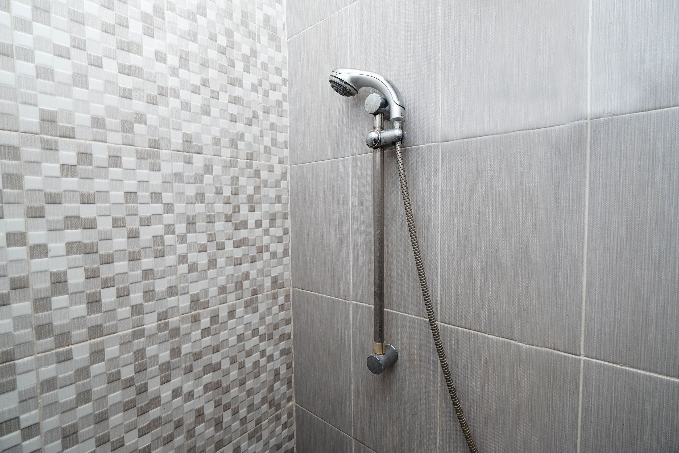 A shower with a handheld showerhead and a flexible hose.