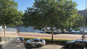 A parking area with cars and a river in the background. - MyCityLofts - Aelbrechtskade (Rotterdam)