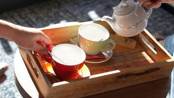 A tray with a teapot and two cups on a wooden surface.