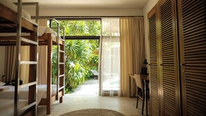 Una habitación con literas, un escritorio y vistas al entorno natural.