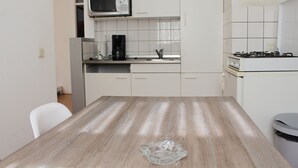 A kitchen with white cabinets, a microwave, a coffee maker, and a gas stove. - MyCityLofts - Schiekade (Rotterdam)