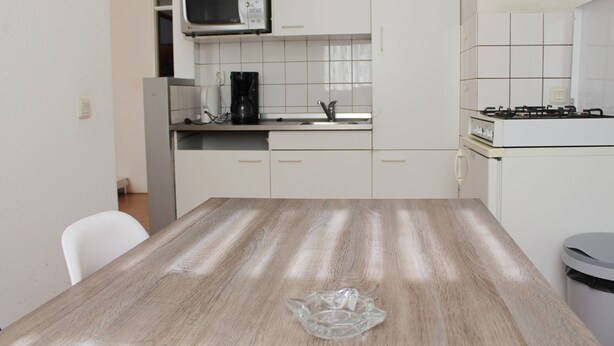 A kitchen with white cabinets, a microwave, a coffee maker, and a gas stove. - MyCityLofts - Schiekade (Rotterdam)