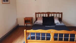 Ein Schlafzimmer mit einem hölzernen Bett, einem Nachttisch und zwei Wandleuchten.