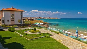 A coastal hotel with a pool area, a landscaped garden, and a view of the sea. - Black Sea Paradise (Sozopol)