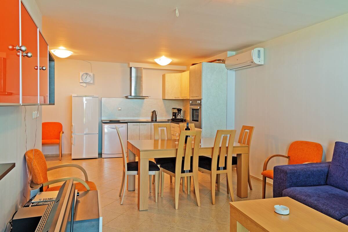 A compact living space with a kitchen, dining area, and seating.