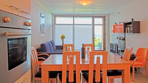 A modern kitchen with a dining area, featuring a large window, a built-in oven, and a seating arrangement. - Black Sea Paradise (Sozopol)