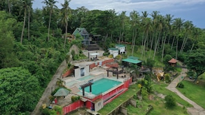 A resort with a swimming pool, guest rooms, and a large tiger statue. - Vinewoods Resorts by Cocotel (Taal)