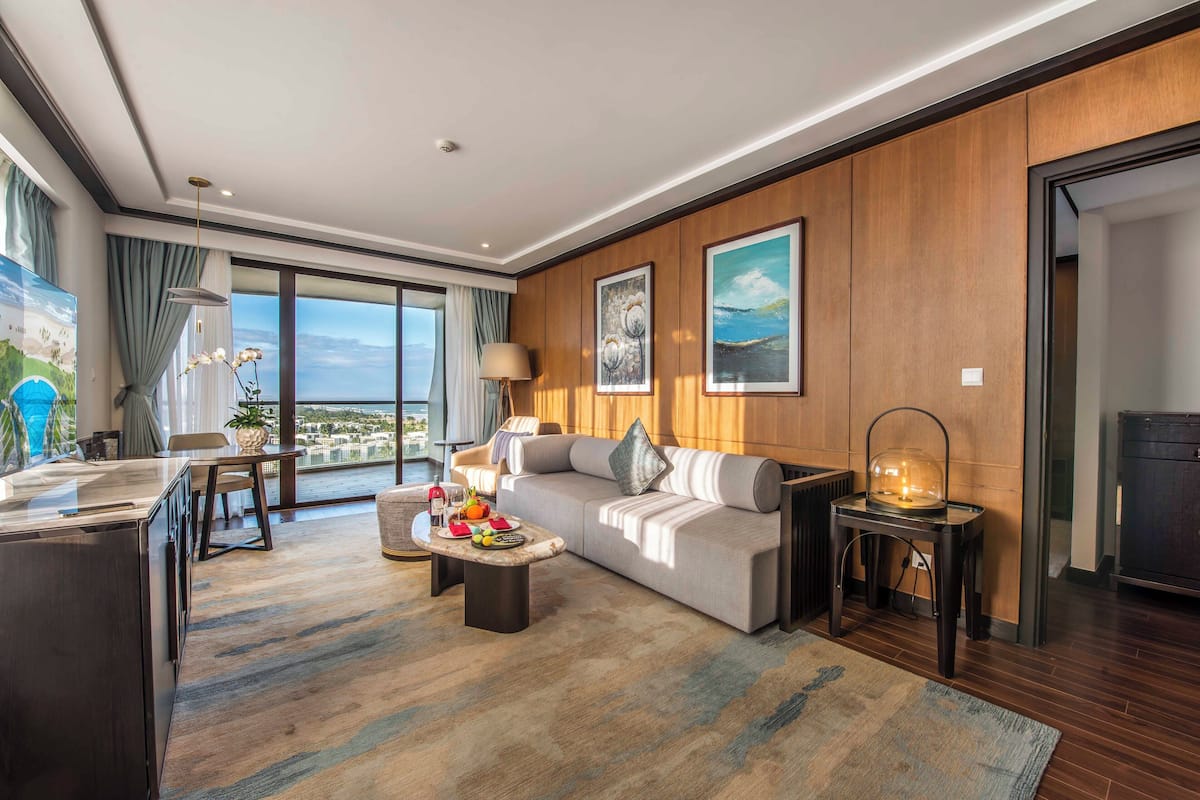 Une chambre d’hôtel moderne équipée d’un canapé, d’une table basse et d’un coin repas.