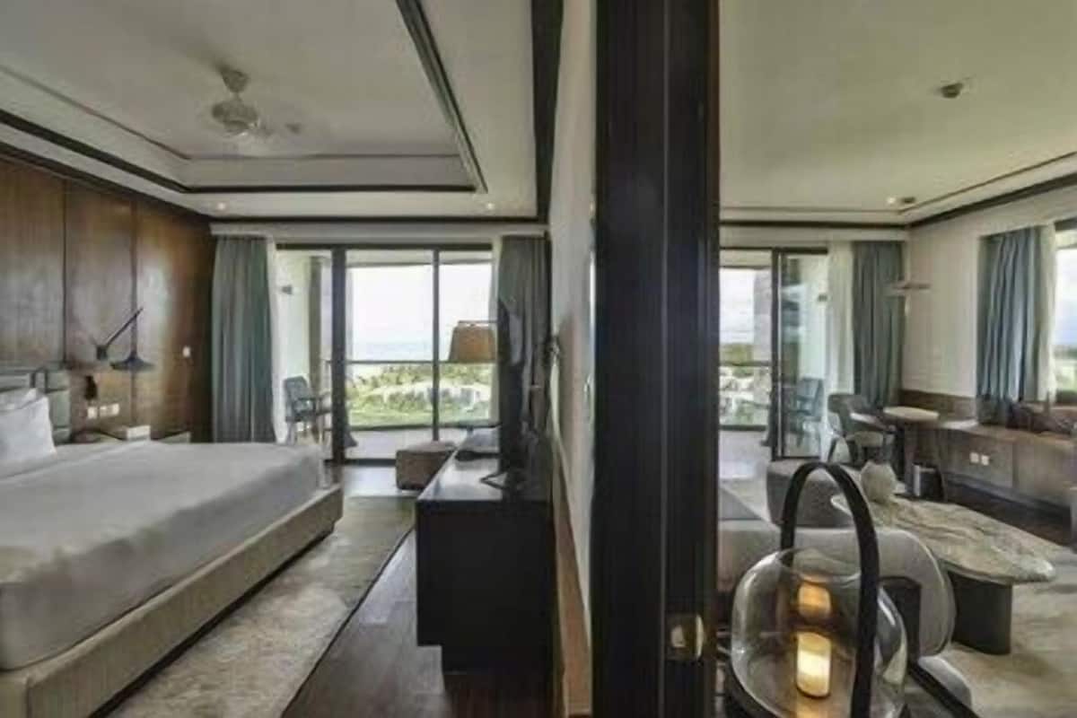 Une chambre d’hôtel moderne dotée d’un grand lit, d’un bureau, d’une chaise et offrant une vue sur l’extérieur.
