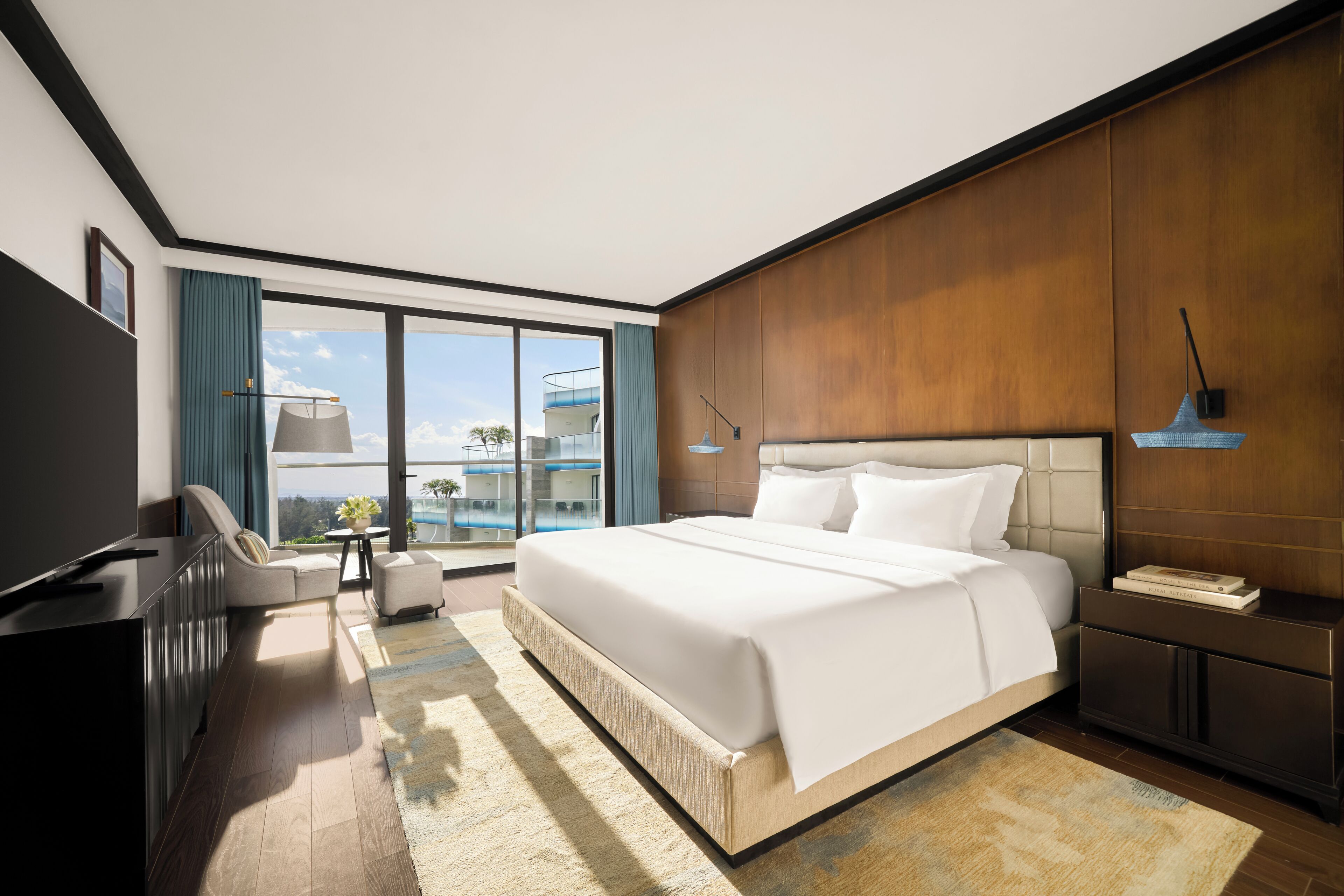 Habitación de hotel moderna con una cama grande, un televisor de pantalla plana, un sofá y vistas a la ciudad.