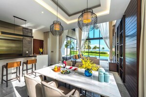 Una cocina moderna con encimera de mármol, luces colgantes y vistas al exterior.