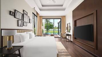 A hotel room with a large bed, a flat-screen TV, a desk, and a view of the outdoors.