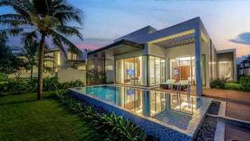 A modern house with a swimming pool, large windows, and a well-maintained garden.