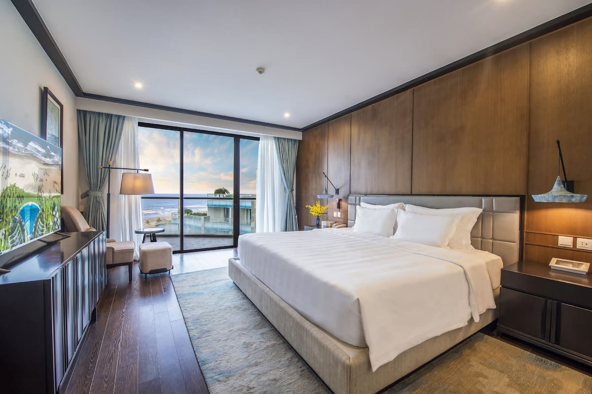 Une chambre d’hôtel moderne avec un grand lit, un bureau et une vue sur la ville.