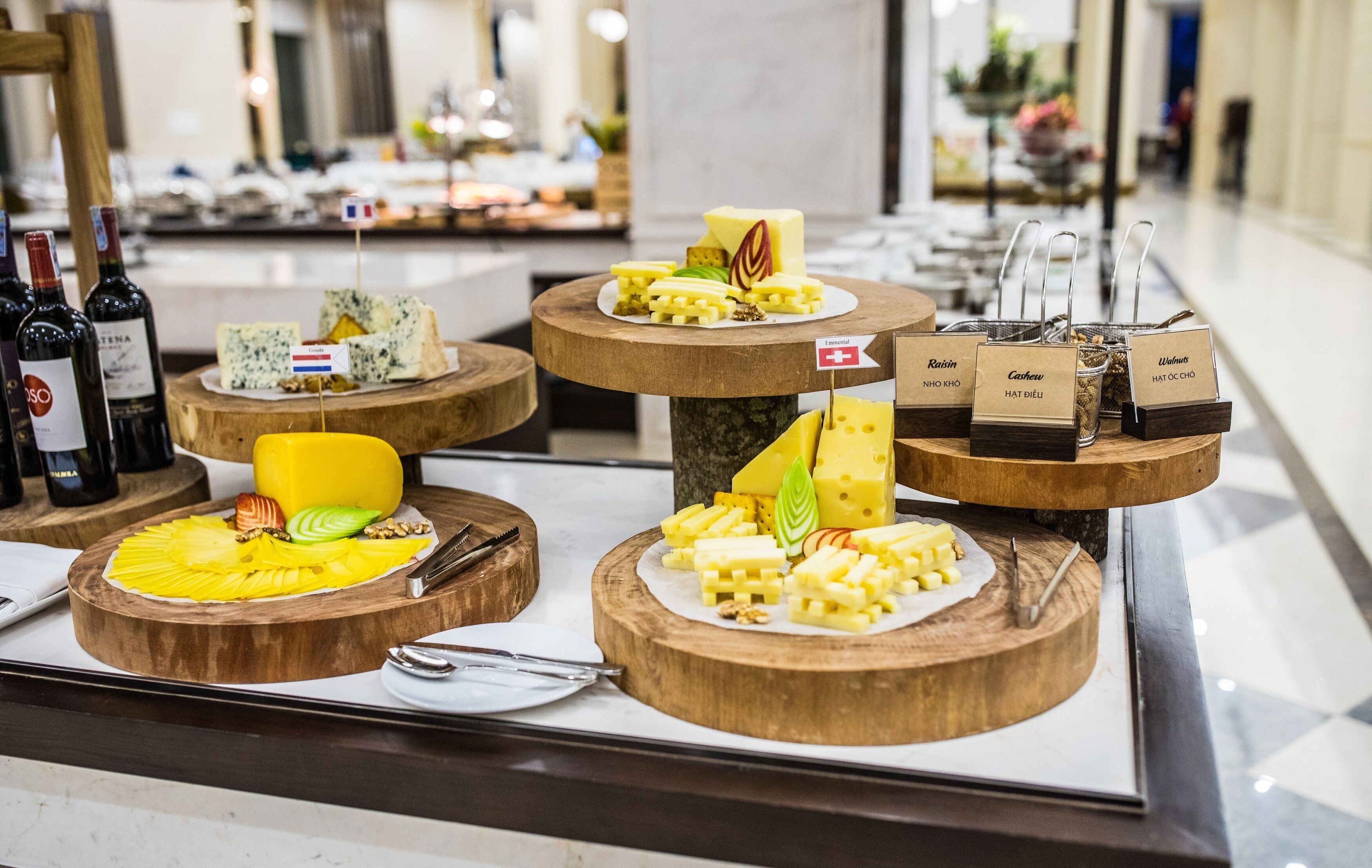 A cheese and wine tasting display with various cheeses and wine bottles.
