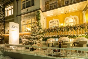 A hotel exterior with snow-covered plants, outdoor seating, and a warm interior glow. - Hotel Villa Aurora (Bad Neuenahr-Ahrweiler)