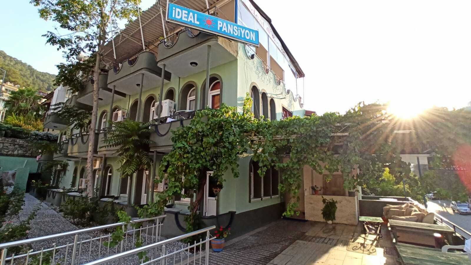 A multi-story building with a sign reading "iDEAL PANSiyon" on the upper floor.
