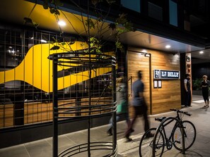 A modern building with a yellow and black facade, a wooden interior, and a sign reading "LT BILLY". - The William Suites (Melbourne)
