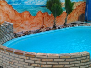 Una piscina techada, una piscina al aire libre, sombrillas