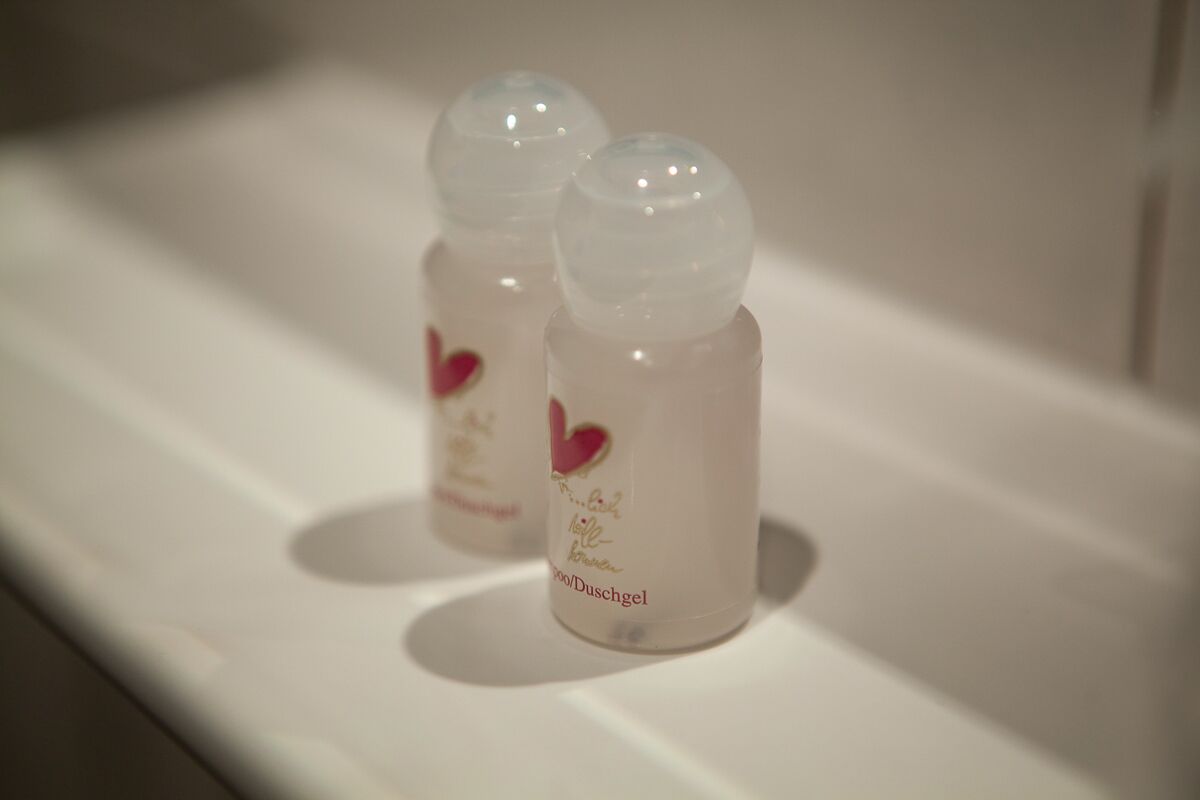 Dos botellas pequeñas con diseños de corazón sobre una superficie blanca.