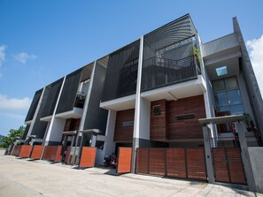 Een modern meerlaags gebouw met een gevel van baksteen en metaal, grote ramen en een plat dak.