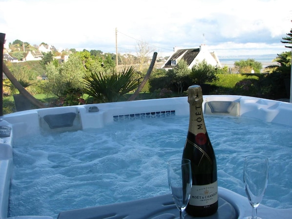 A hot tub with a bottle of Moët & Chandon champagne and two glasses.