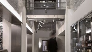 A modern interior with exposed brick walls, a mezzanine level, and a bar area with stools. - Boutique Hotel Ottilia (Copenhagen)