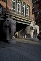 A building with a balcony and two elephant statues.