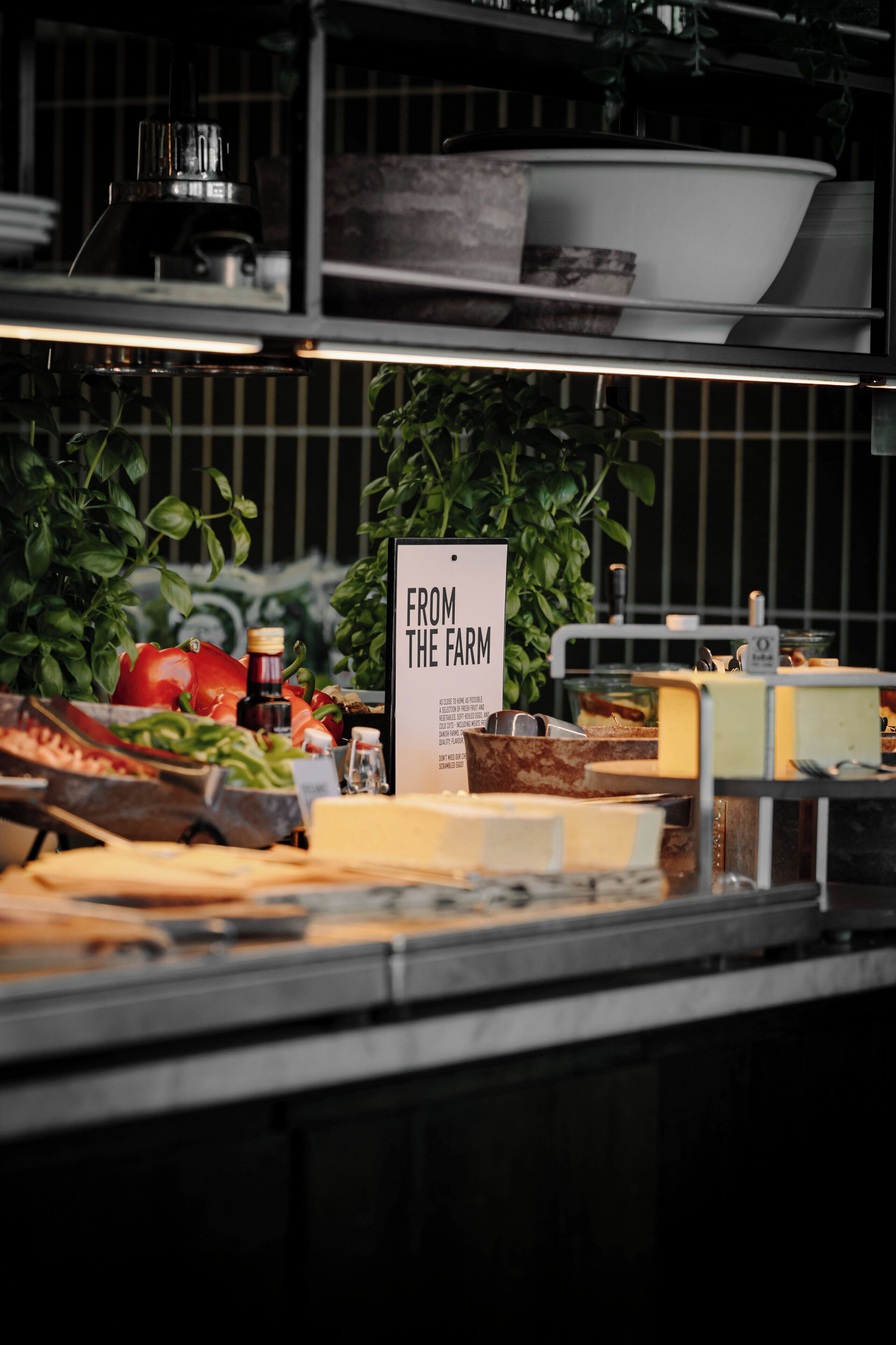 Een buffetgedeelte met een bord waarop 'VAN HET BOERENLAND' staat, en diverse soorten eten, zoals groenten en kaas.