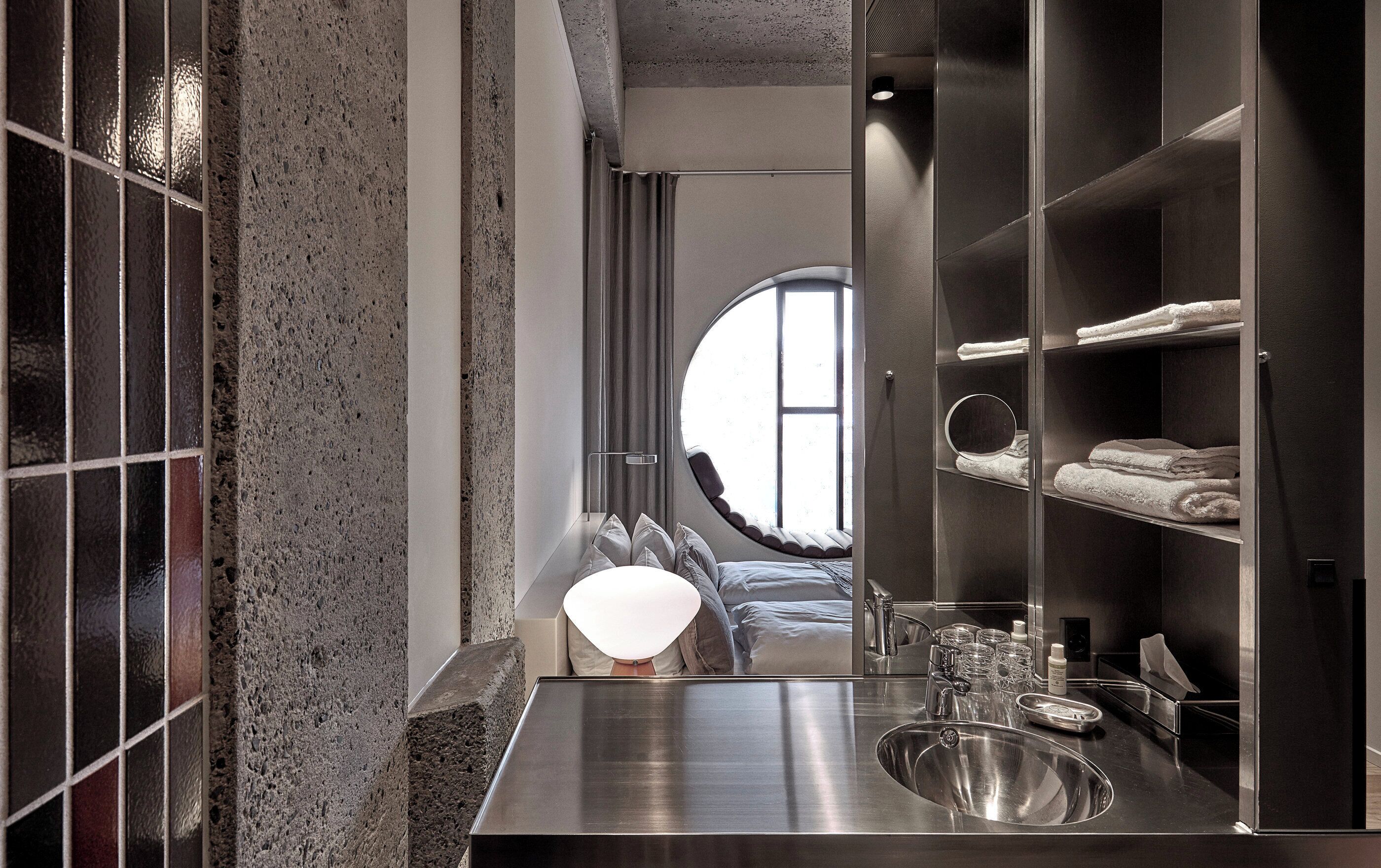 deluxe room with round window | bathroom | shower, eco-friendly toiletries, hair dryer, towels