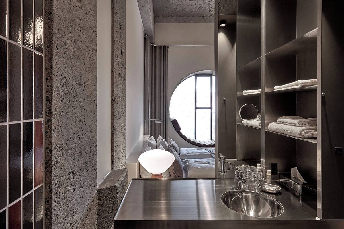 deluxe room with round window | bathroom | shower, eco-friendly toiletries, hair dryer, towels