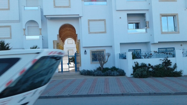 A multi-story building with a central entrance featuring an archway.