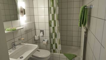 A bathroom with a sink, toilet, and shower curtain.