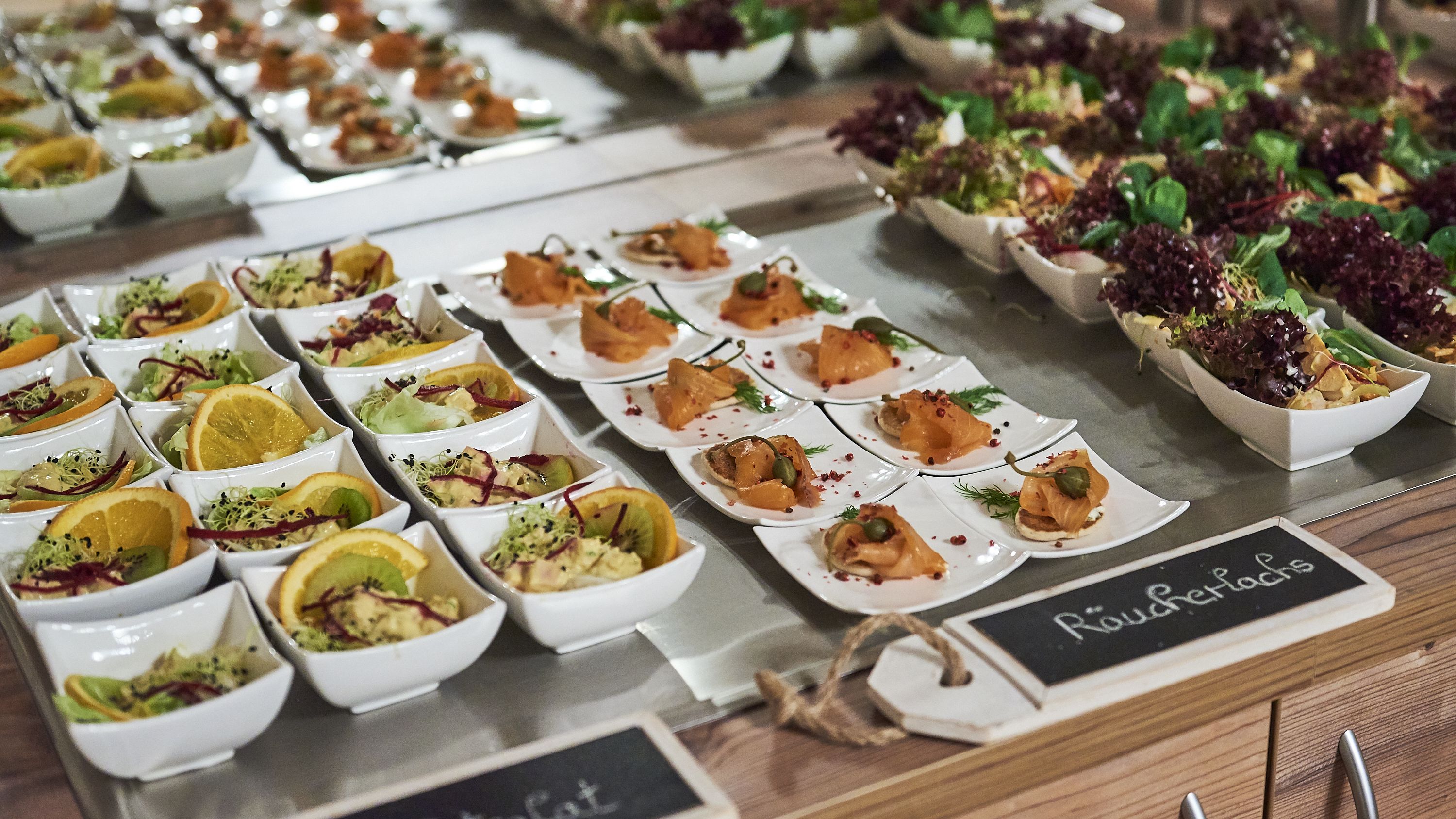 A buffet with various dishes, including salads and appetizers, arranged on a table.