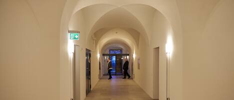 A hallway with arched ceilings and a sign indicating an exit.