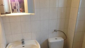 A bathroom with a white sink, a toilet, and a mirror above the sink. - Zimmer in Herne (Herne)