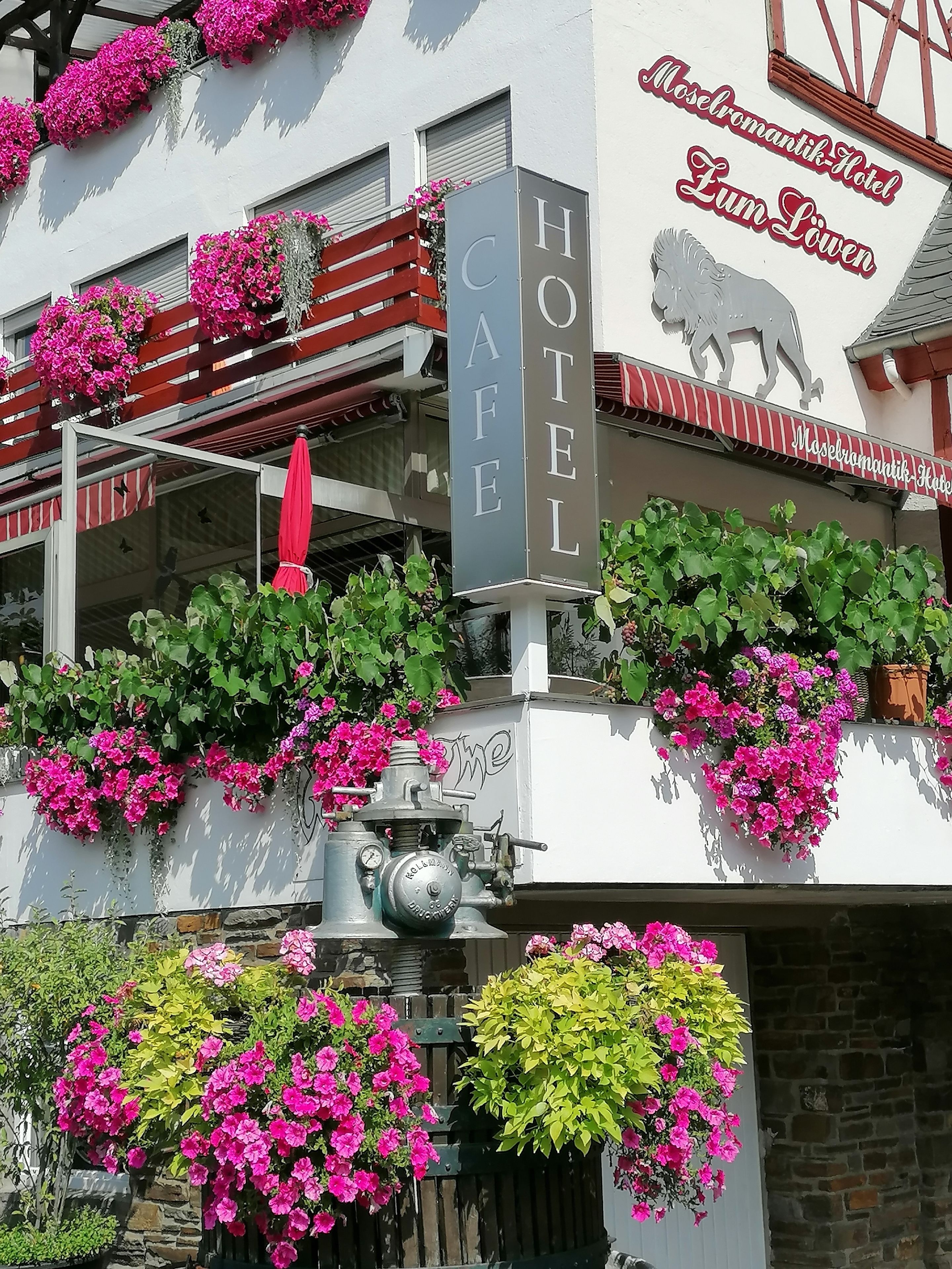 A hotel with a sign reading "Hotel Cafe" and "Moser romantik Hotel Zum Loven".