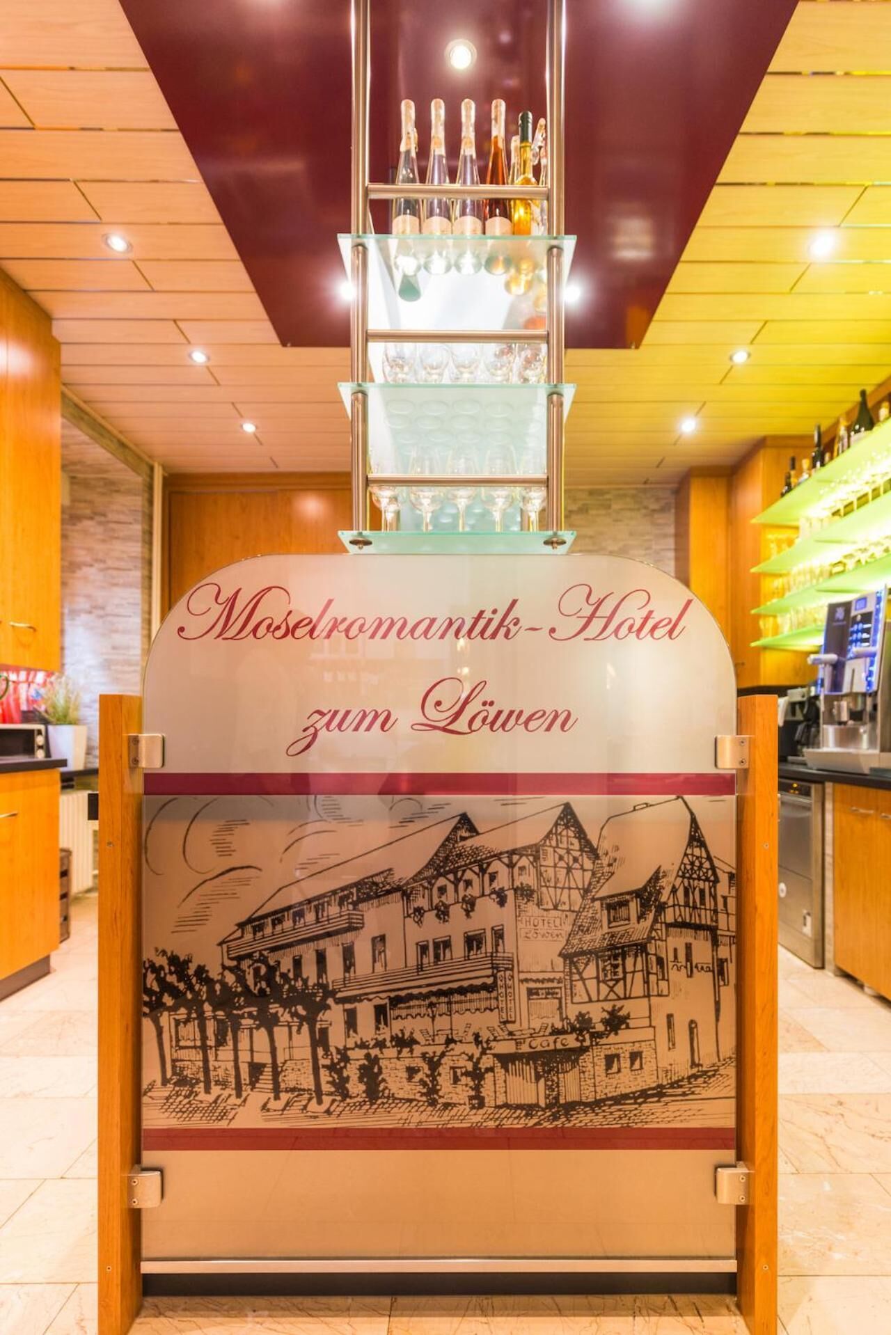 A hotel sign with a town illustration and a wine rack above it.