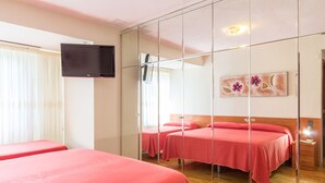 A hotel room with two beds, a TV mounted on the wall, and a painting above the beds. - Pensión La Rioja (Logroño)