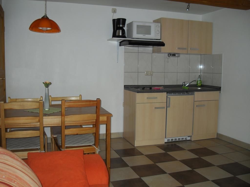 Una cocina funcional con armarios de madera, un microondas y un lavamanos.