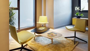 Una sala de estar moderna con dos sillones amarillos, una mesita de centro, una lámpara y una planta en maceta.