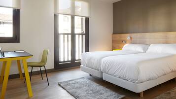 Una habitación de hotel moderna con una cama grande, un escritorio y una silla.