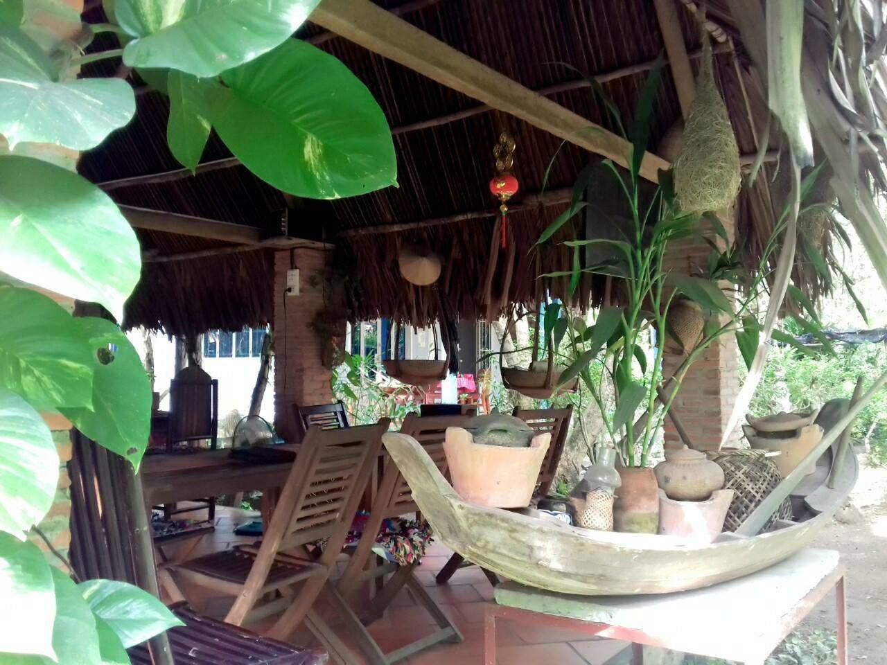 A rustic outdoor seating area with wooden furniture and hanging planters.