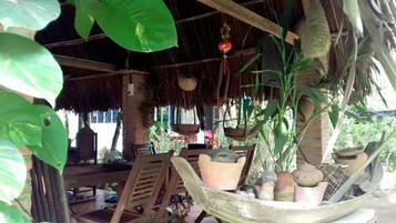 A rustic outdoor seating area with wooden furniture and hanging planters.